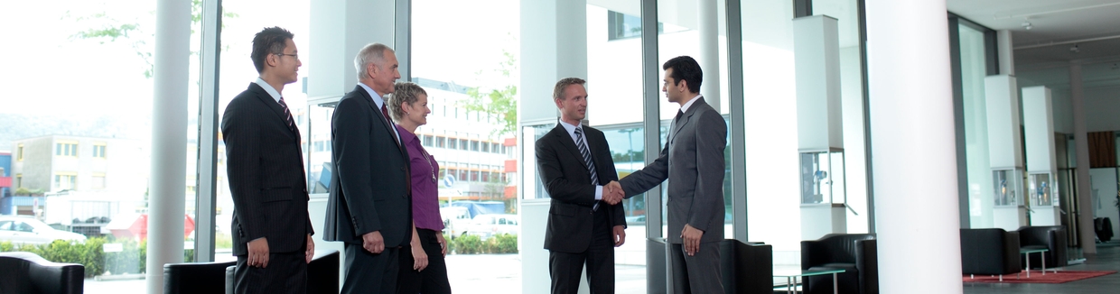 Mitarbeiter und Kunde beim Händeschütteln in der Lobby von Endress+Hauser