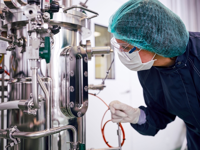 Scientifique avec un fermenteur pour la production biopharmaceutique dans l'industrie des sciences de la vie Fermenteur et scientifique en production biopharmaceutique