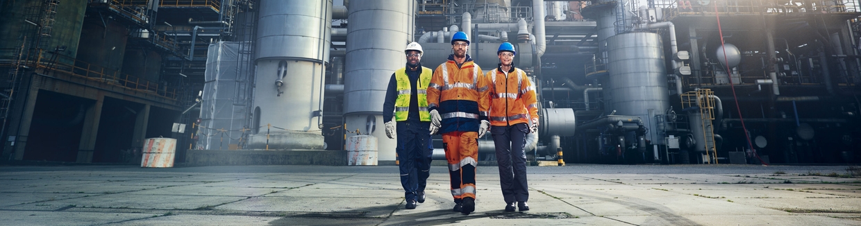 Close up picture of an engineer in front of a refinery