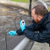 Ein Mann prüft eine Sauerstoffmessstelle mit einem tragbaren Sauerstoffmessgerät
