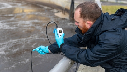 Ein Mann prüft eine Sauerstoffmessstelle mit einem tragbaren Sauerstoffmessgerät